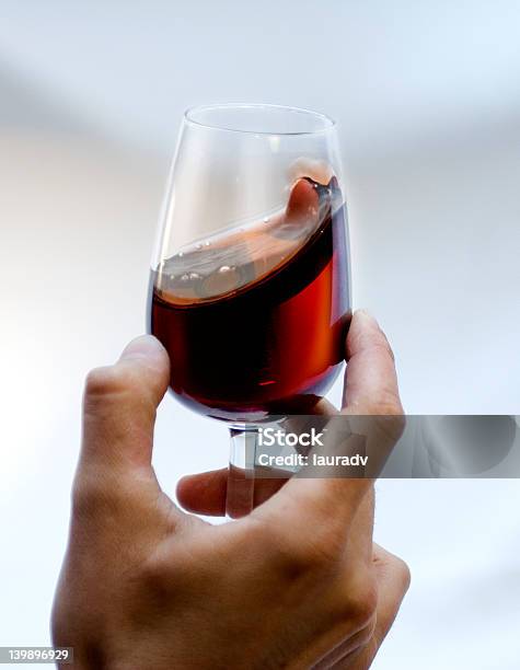 Bicchiere Da Vino Rosso Tinto In Una Mano - Fotografie stock e altre immagini di Vino - Vino, Bicchiere, Adulto