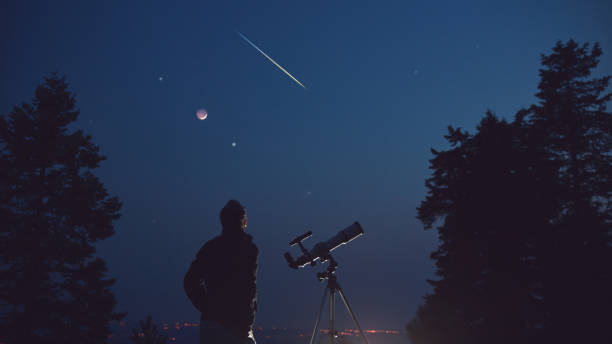 silueta de un hombre, telescopio, estrellas, planetas y estrella fugaz bajo el cielo nocturno. - lluvia de meteoritos fotografías e imágenes de stock