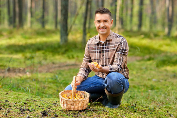 istock happy man with basket picking mushrooms in forest 1398970364