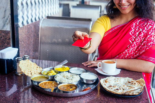 Woman hand holding a teapot and pouring tea in a white ceramic cup