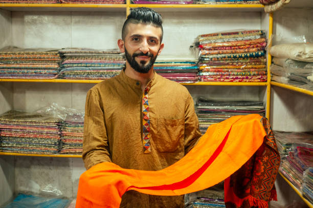 작은 가게 주인 인도 남자는 아람볼 고아에있는 그의 가게에서 숄을 파는 - nepal bazaar kathmandu textile 뉴스 사진 이미지