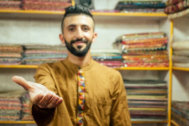 petit propriétaire de magasin indien homme vendant des châles dans son magasin à arambol goa - nepal bazaar kathmandu textile photos et images de collection