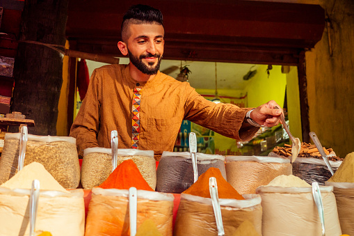 indian sallerman showing his small shop on arambol goa market.