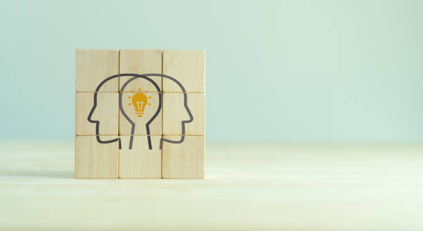 istock Knowledge and ideas sharing between two people head icon on wooden cube. Transferring knowledge, innovation, brainstorming concept. Business strategies to technology evolution reskill and new skill. 1398971985
