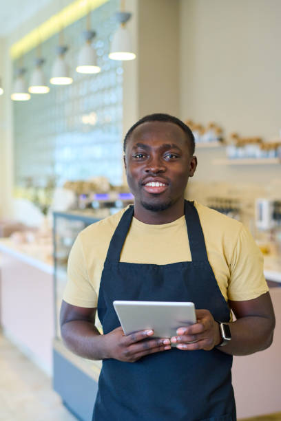 istock Waiter with tablet pc working in coffee shop 1398972656