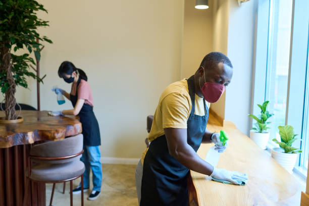 istock Waiters cleaning tables in cafe before opening 1398973106