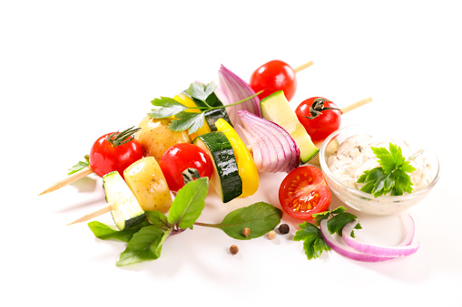 plate of barbecue vegetable skewer on white background