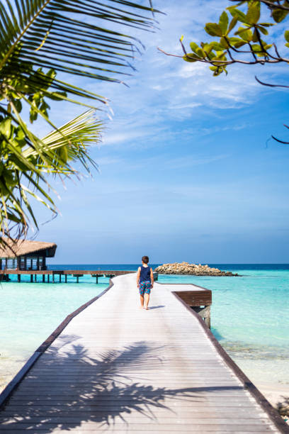 istock Little kid walking on a pathway over the ocean 1398974001