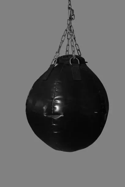 Black speed boxing ball bag hanging on metal chains, cut out
