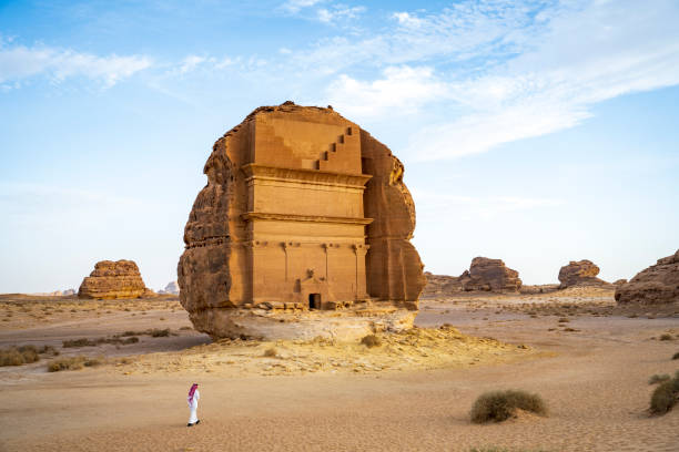 Tomb of Lihyan, son of Kuza, in northwestern Saudi Arabia Full length view of Middle Eastern man in foreground and enormous iconic rock-cut tomb, the first Saudi UNESCO World Heritage Site. saudi arabia stock pictures, royalty-free photos & images