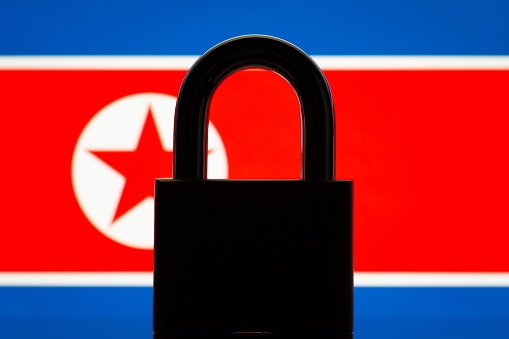 Silhouette of closed lock near flag of North Korea