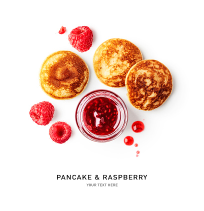 Pancake and raspberry jam creative layout isolated on white background. Healthy eating and sweet food concept. Tasty breakfast with cappuccino, small pancakes and berries. Flat lay. Design element