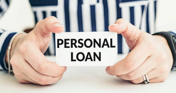 istock PERSONAL LOAN text on card in woman hands 1398975360