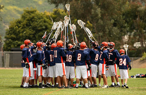 lacrosse team spirit Image of a lacrosse team holding their stick up high prior to the start of the game. team sport photos stock pictures, royalty-free photos & images