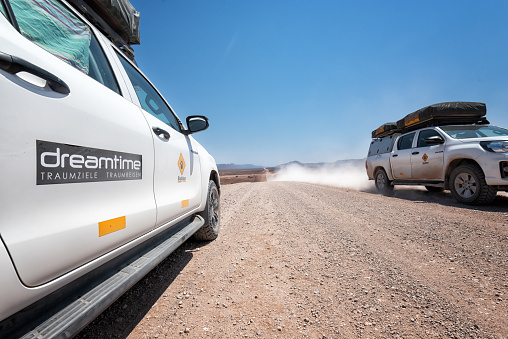 Damaraland, Namibia - October 13, 2021: Two Off-road vehicles crossing on a dirt road in the Damaraland Region in direction of Etosha National Park. Fascinating loneliness on the road trip across Namibia.