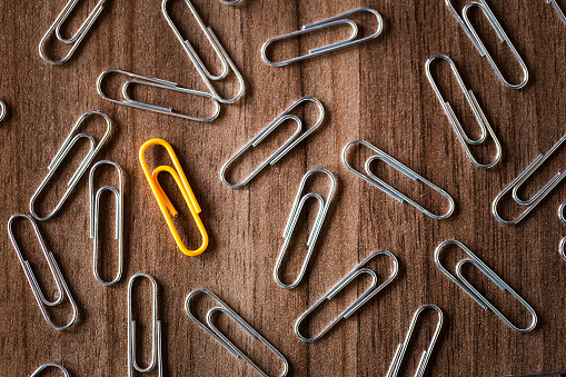 Paper clips on green background with copyspace. View from above with copy space