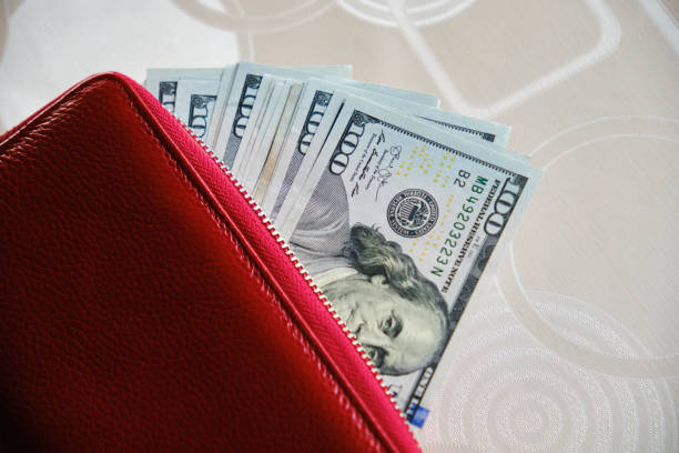 istock A wallet with a hundred dollar bills sticking out of it 1398981468