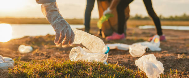 istock woman hand picking up garbage plastic bottle for cleaning at park 1398982324