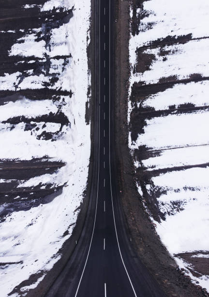 vista aerea di una strada curva con neve in inverno. - weather vane foto e immagini stock