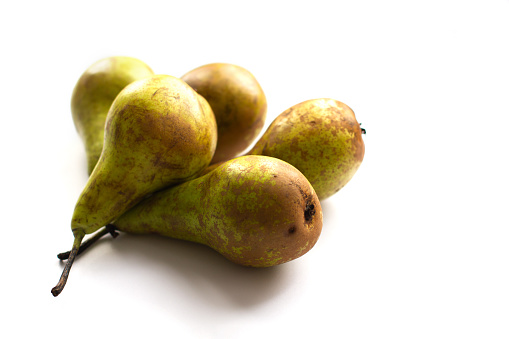 A group of five fresh sweet organic ripe conference pears on a white isolated background. Soft focus.
