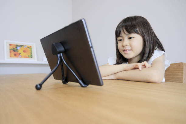 fille japonaise regardant une vidéo sur tablette pc (7 ans) - 6 7 years photos et images de collection