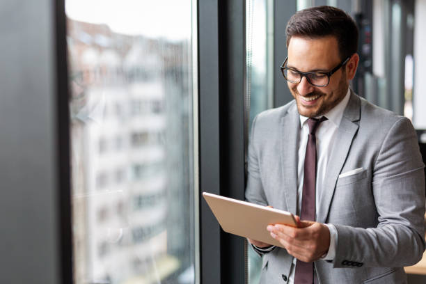 istock Happy business man manager holding tablet and working in modern office 1398986775