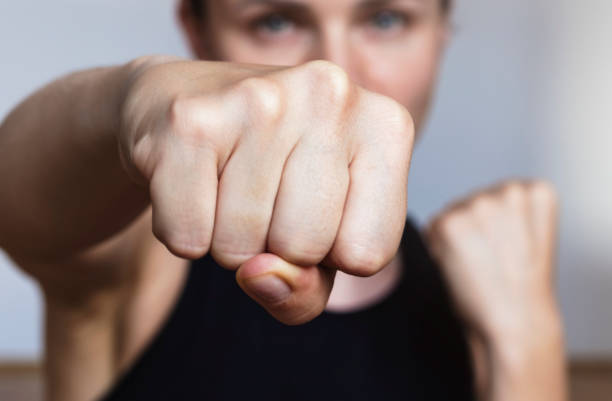 istock Female athlete punching at camera, focus on fist. 1398987310