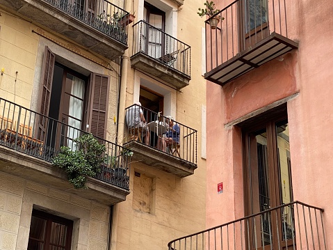 Barcelona, Spain, - May 23, 2022. Senior Couple having breakfast on typical balcony of a historical apartment.