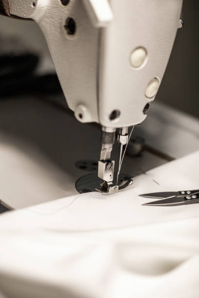 istock Close-up sewing machine needle and white fabric 1398987588