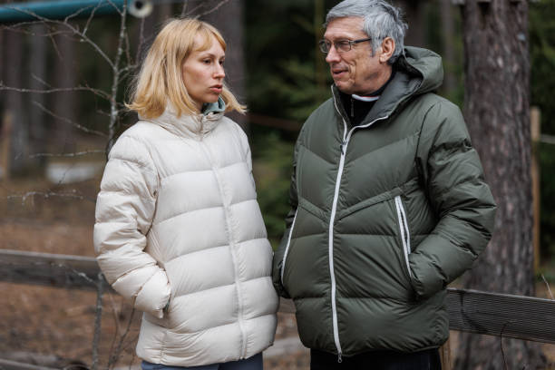 father and daughter going for a walk on an spring's day and talking - senior adult winter senior women daughter imagens e fotografias de stock