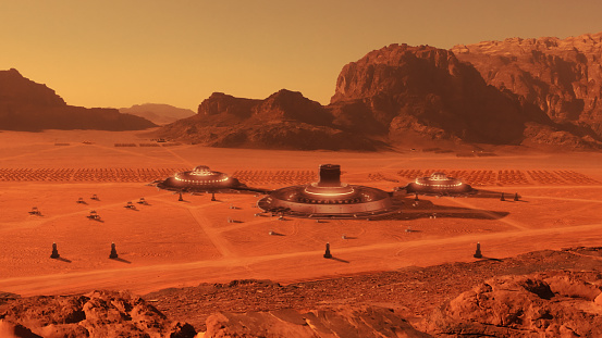 Mars base surrounded by mountains. Red sand and rocks with footprints on the ground. Looking for new Earth concept. NASA Public Domain Imagery