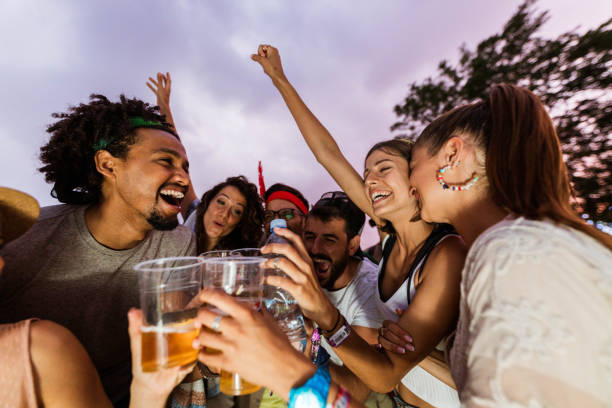 istock Young cheerful people having fun while toasting at the outdoor party. 1398990003