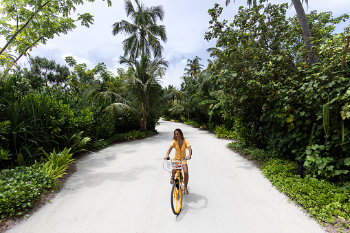 Young happy woman having fun while riding a bike in nature.