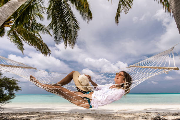 istock Happy woman enjoying in hammock on the beach. 1398992185