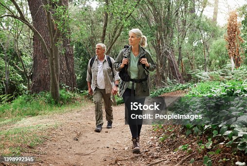 istock A mature caucasian couple out for a hike together. Senior man and woman smiling and walking in a forest in nature 1398992345
