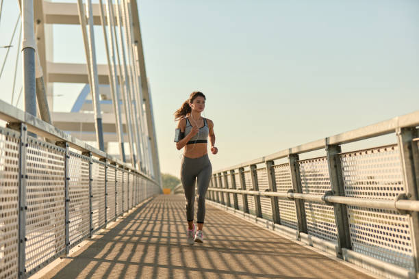 istock Female jogger running over the bridge 1398993454
