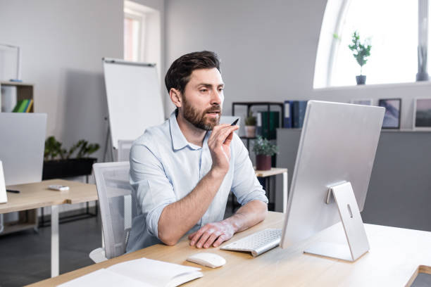 istock Freelancer looking at computer screen, man talking on video call, businessman in office working remotely 1398993688