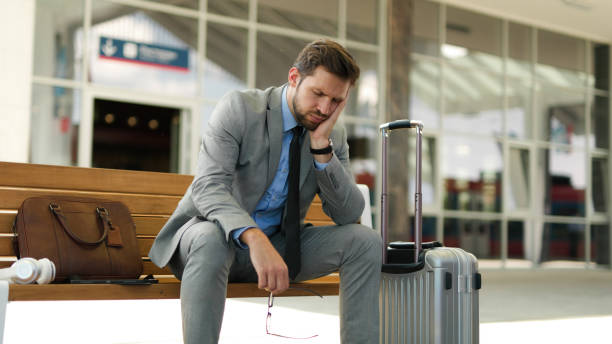 istock Pensive businessman is waiting at train station alone 1398994007