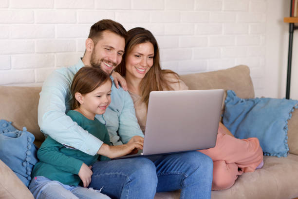 istock Smiling family relaxing at home and using laptop together 1398994148