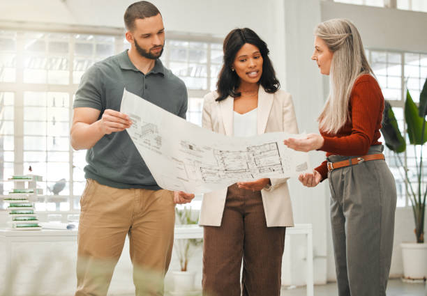 istock Diverse architects talking about a blueprint. Focused businesspeople planning their strategy. Engineers looking at a building plan. Boss talking to staff about a blueprint. 1398994328