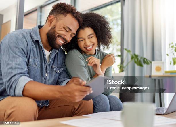 Young Happy Mixed Race Couple Going Through Documents And Using A Digital Tablet At A Table Together At Home Cheerful Hispanic Husband And Wife Smiling While Planning And Paying Bills Boyfriend And Girlfriend Working On Their Budget Stock Photo - Download Image Now