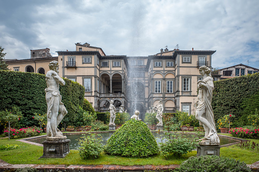 Luuca, Tuscany, Italy, 09 May 2022 - Gardens of Pfanner villa inside Medieval city walls of Lucca, with grass fountains and statues.