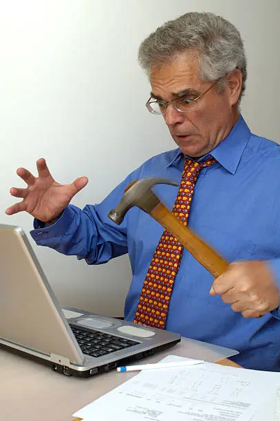 A businessman, fed up with his laptop crashing, goes berserk and takes a hammer to it.