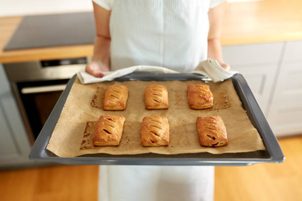 istock woman holding baking tray with pies at kitchen 1398998751