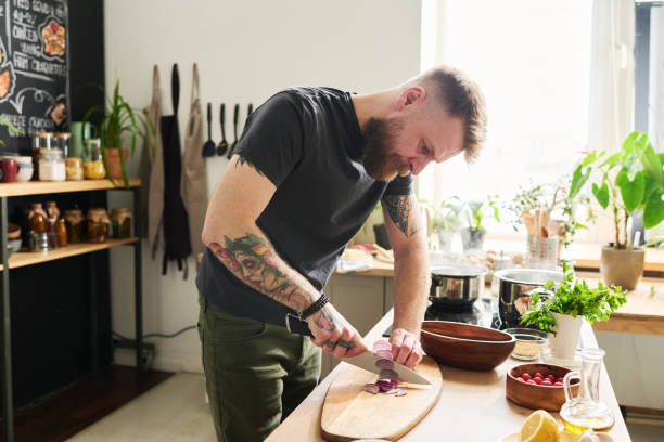 istock Tattooed Man Cutting Onion 1398999241