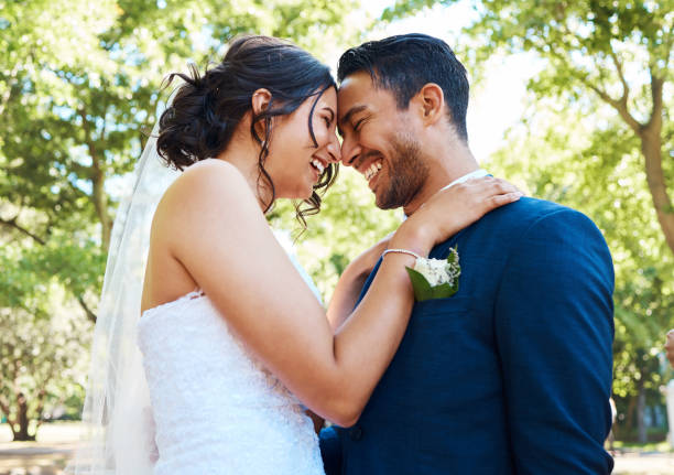 istock Happy romantic couple looking joyful while standing together on their wedding day. Bride and groom touching foreheads and posing for wedding picture 1399000055