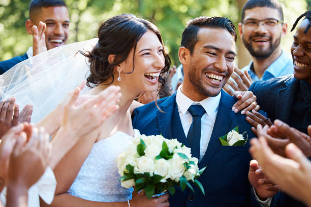 radosna para młoda stojąca razem podczas powitania gości po ceremonii ślubnej. nowożeńcy wyglądają na szczęśliwych, podczas gdy przyjaciele i rodzina gratulują im małżeństwa - weddings brown hair cheerful affectionate zdjęcia i obrazy z banku zdjęć