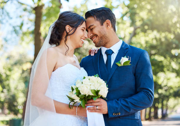 istock Happy romantic couple standing together holding a bouquet and touching foreheads while posing together on their wedding day 1399000708
