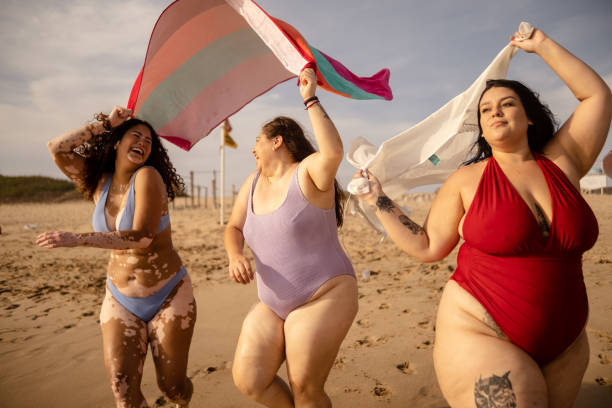 istock Young woman friends walking on the beach 1399001136