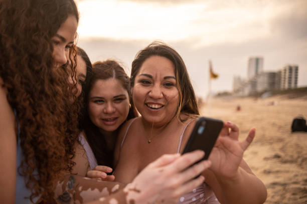 istock Friends using smartphone in the beach 1399001296